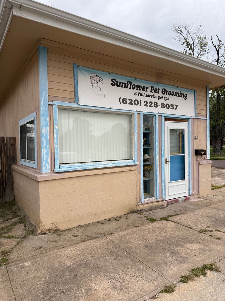 Small beige storefront with a sign for “Sunflower Pet Grooming” and a glass entrance door.