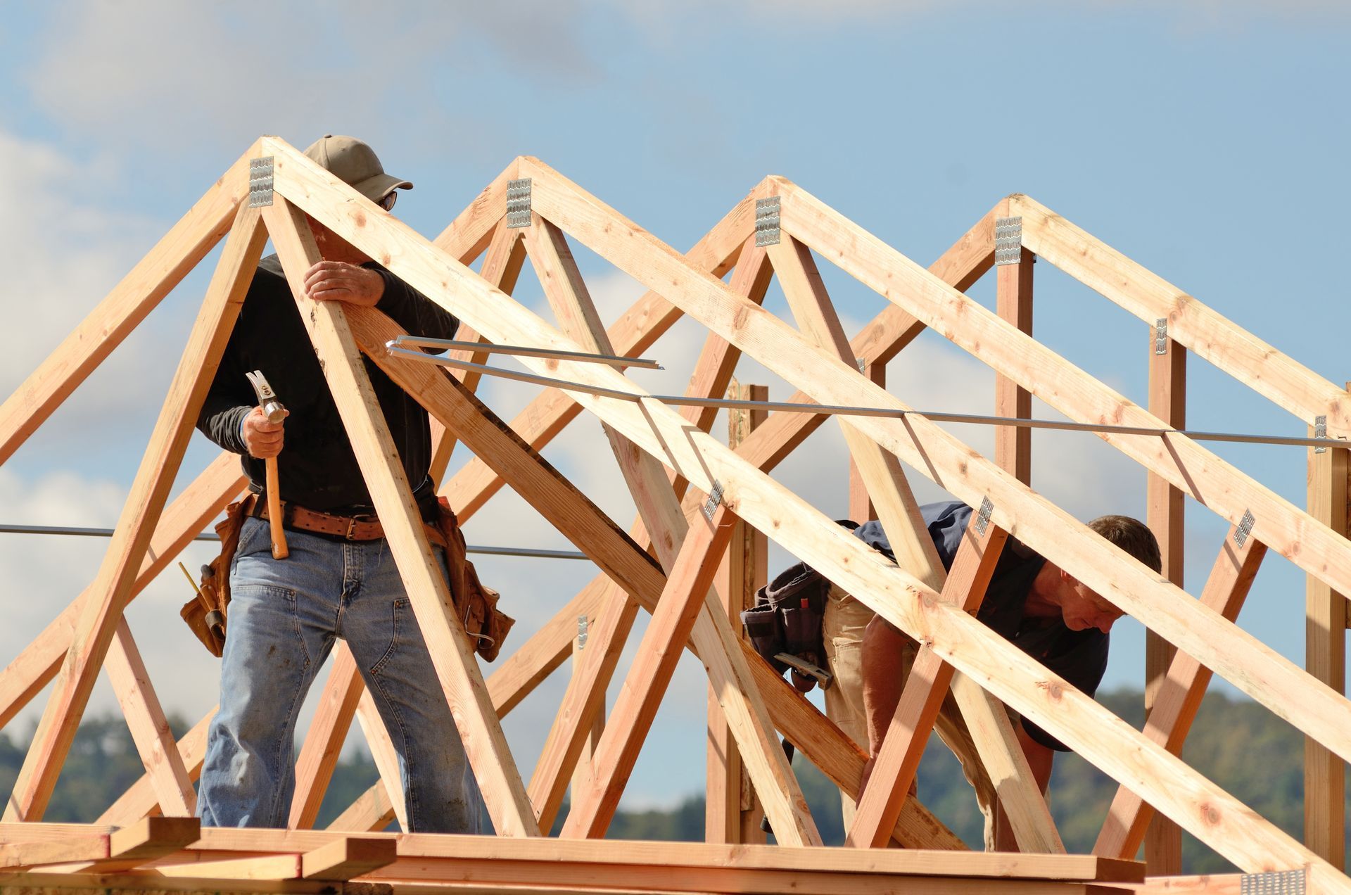 Roof Wood Truss installed by Roof Truss Co. in Atlanta, GA Workers installing engineered wood roof trusses on a building frame.
