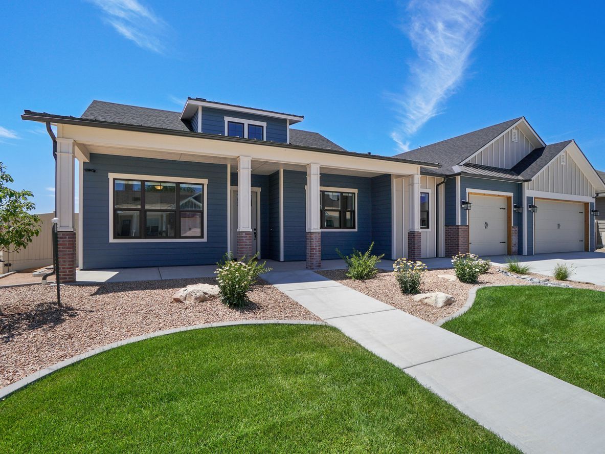 A large blue house with a concrete walkway leading to it.