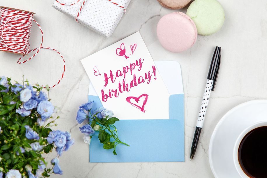 A birthday card is sitting on a table next to a pen.