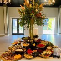 Lavish buffet table with floral centerpiece in a bright banquet hall