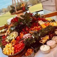 Colorful fruit platter and dips arranged on a table at an outdoor gathering