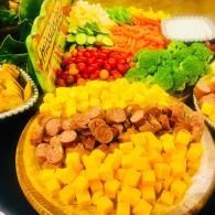 Assorted fruits and vegetables arranged in a colorful market-style display on trays