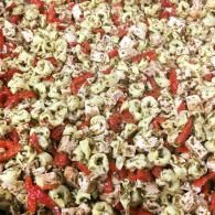 Close-up of popcorn mixed with red seasoning and herbs
