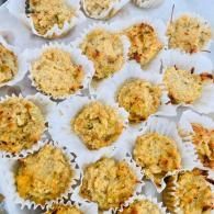 Coconut macaroon cookies in white paper cups on a tray, golden-brown and crumbly
