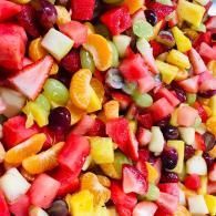 Colorful mixed fruit salad with strawberries, orange segments, grapes, and melon pieces