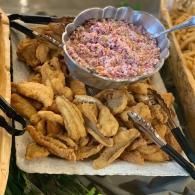 Tray of fried seafood with pink coleslaw and lemon wedges