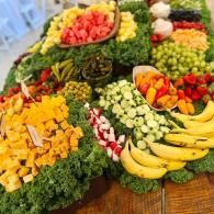 Assorted colorful fruit and vegetable platters arranged on a table for a buffet display