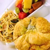 Puff pastry with pasta and fruit in a white takeout container