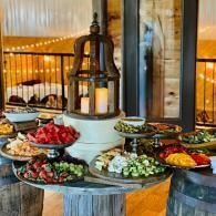 Buffet table with colorful salads and dishes arranged around a decorative lantern indoors