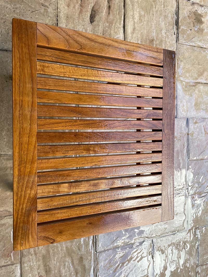 A wooden tray is sitting on top of a brick floor.