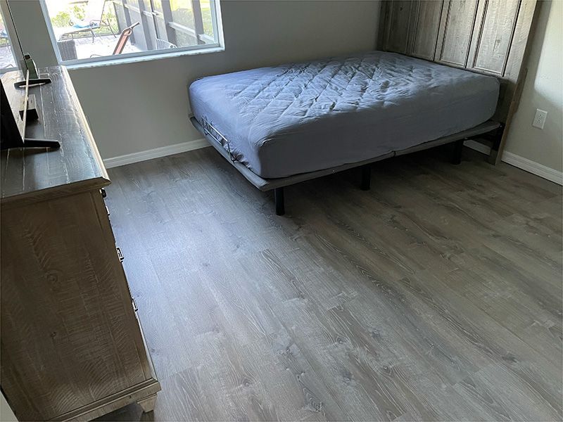 A bedroom with a bed , dresser , and television.