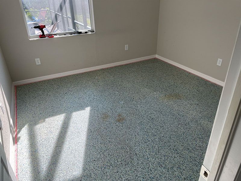 A room with a carpeted floor and a window.