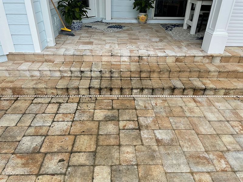 A brick walkway with steps leading up to a house.