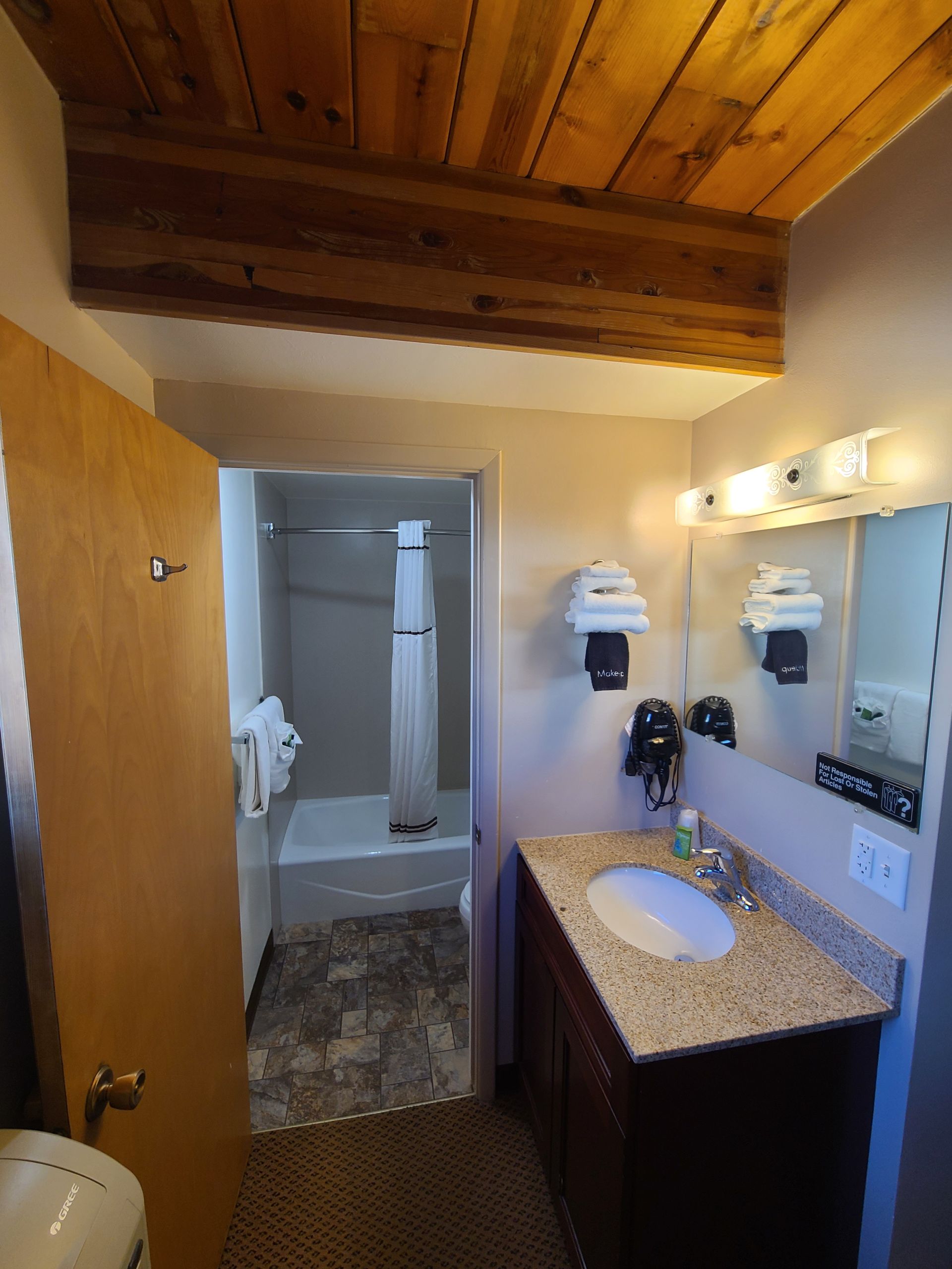 Bathroom with a vanity, shower stall, and exposed wood ceiling beam.