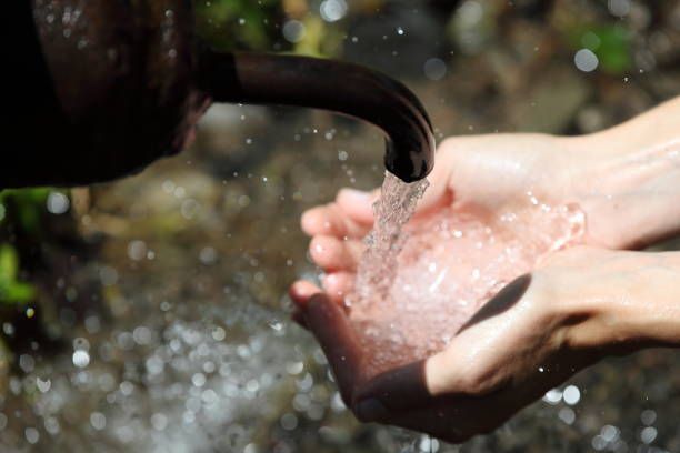 Person is Pouring Water into their Hands from a Faucet — Uxbridge, MA — Darling's Water Well Company