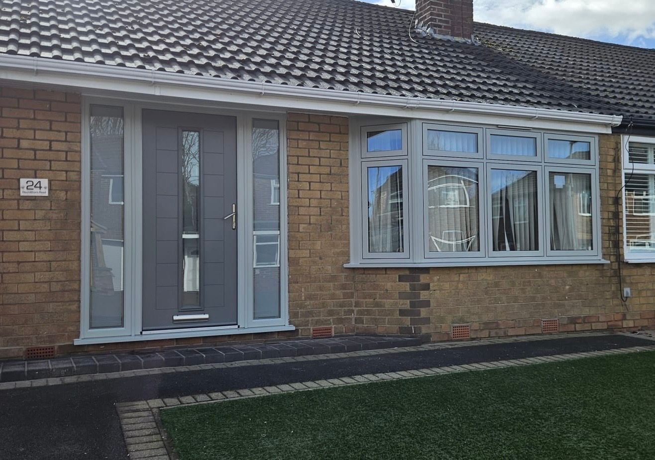 Modern composite front door with sidelights and flush sash windows fitted to bungalow in Manchester