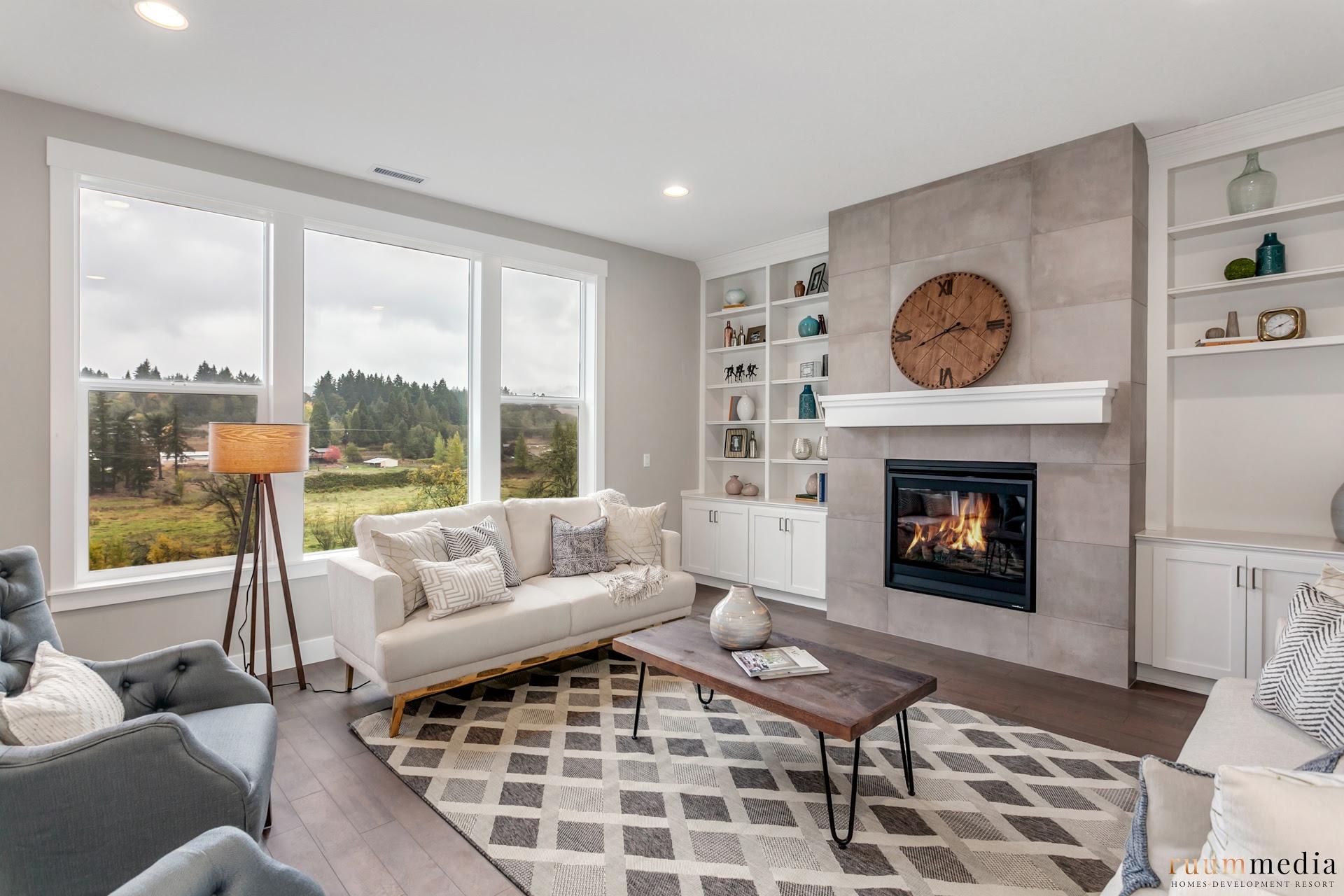 Living room filled with furniture, a large window and a fireplace