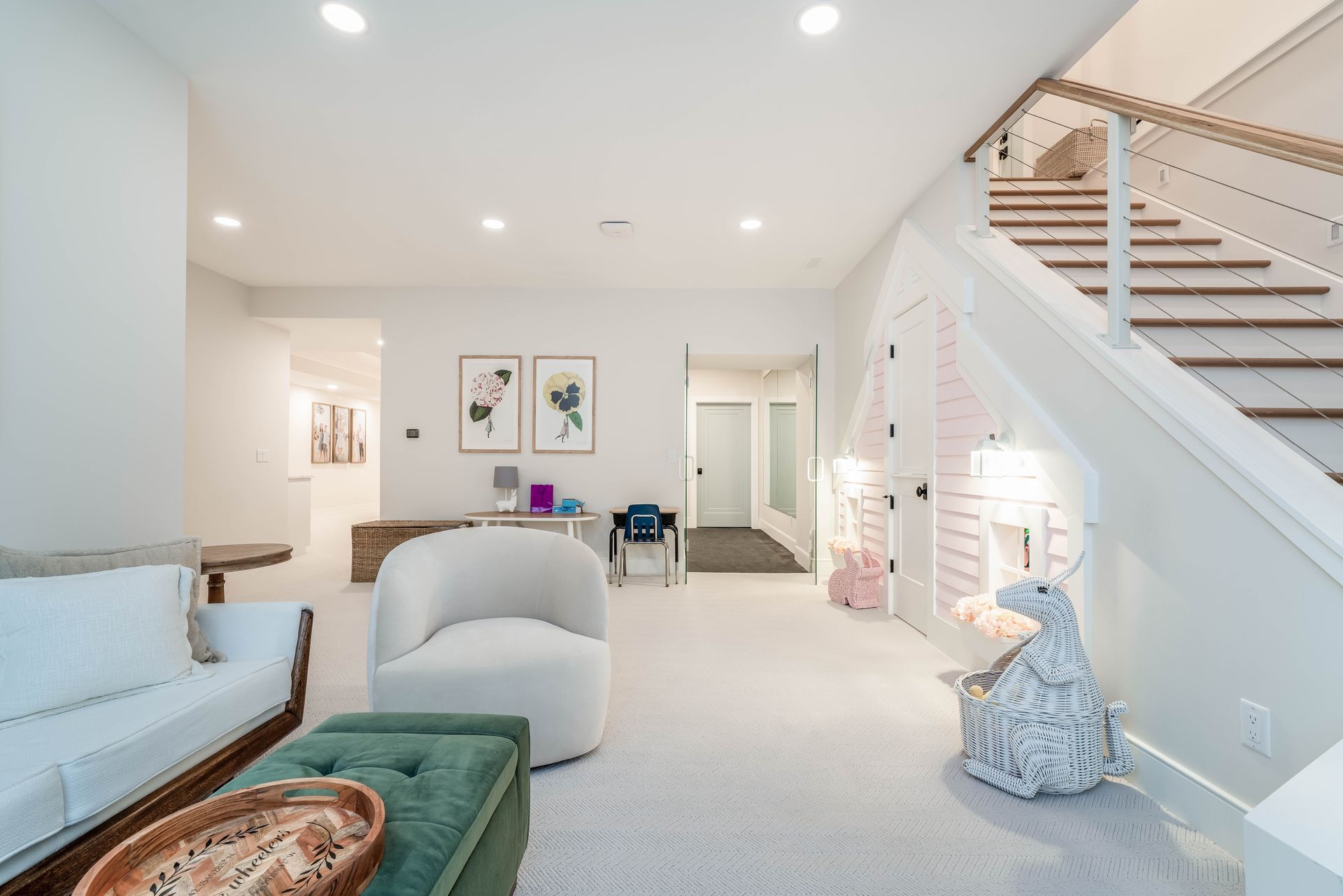 Bright open living room with white sofa, staircase, and soft neutral decor