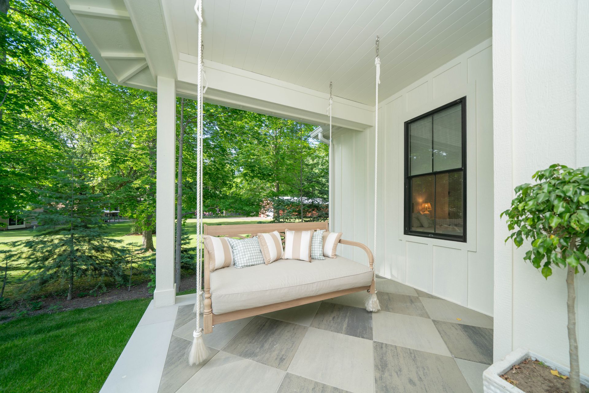 There is a porch swing on the porch of a house.