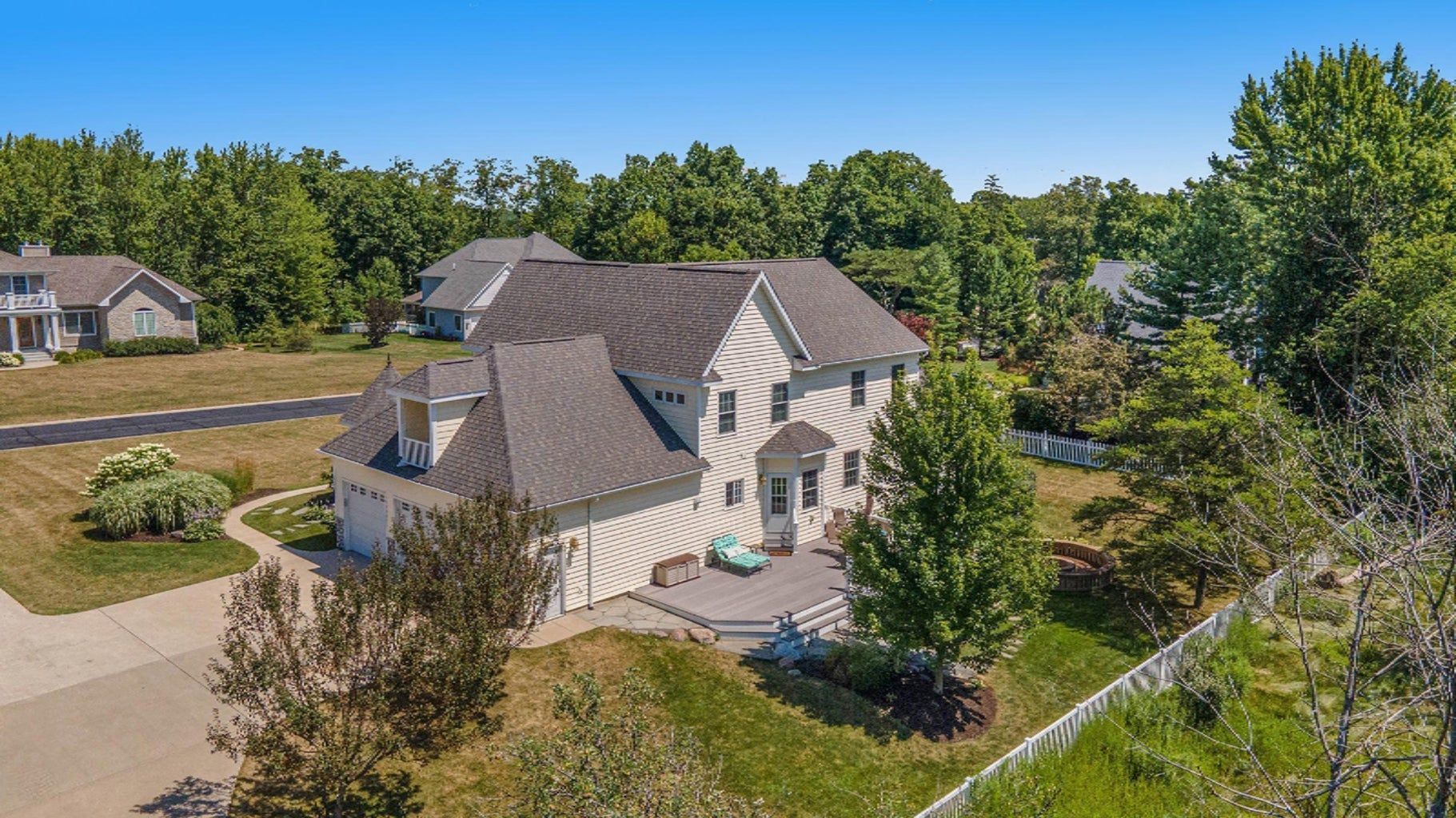 An aerial view of a large white house surrounded by trees.