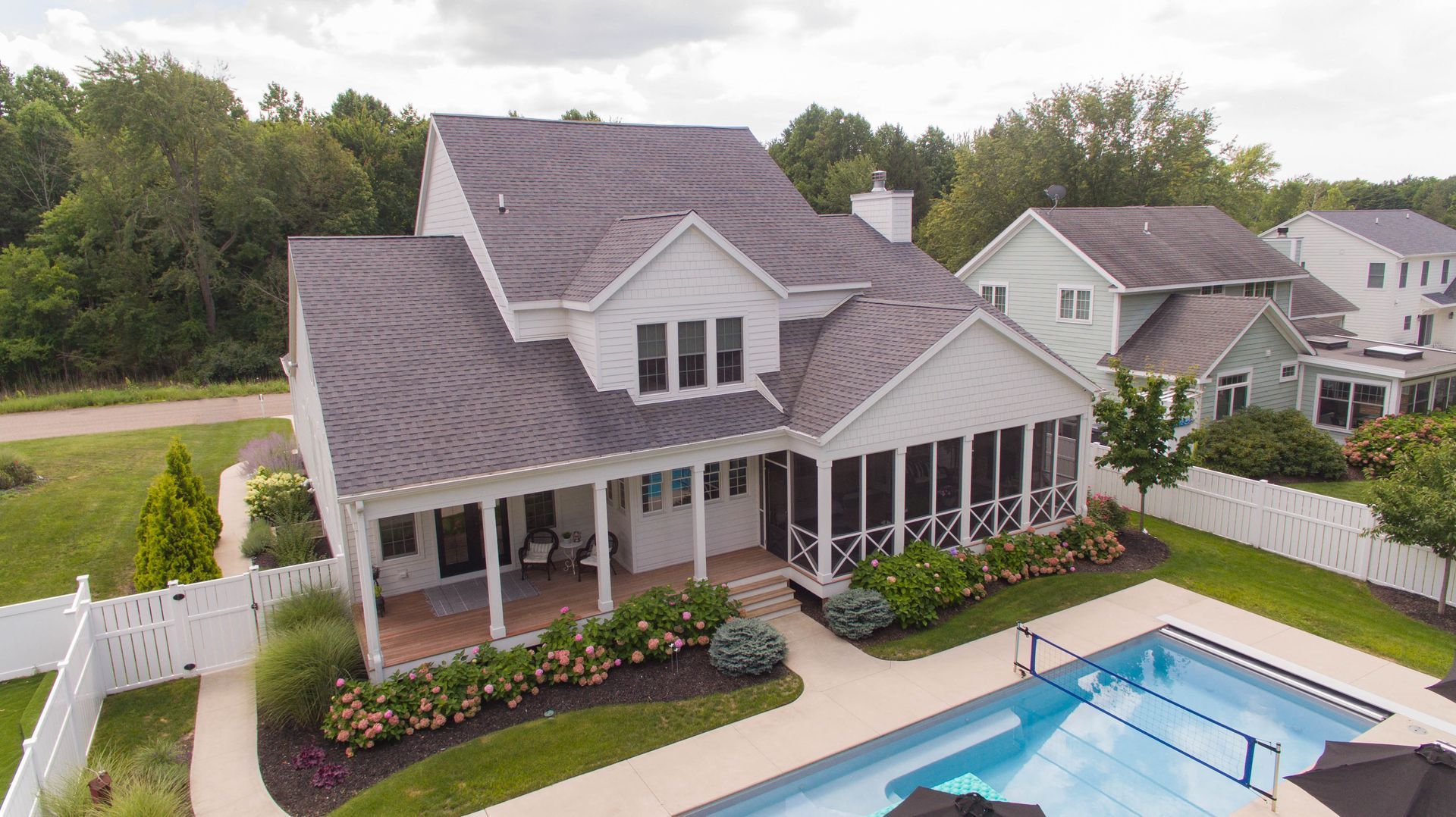 Suburban home with a screened porch, landscaped yard, and backyard swimming pool