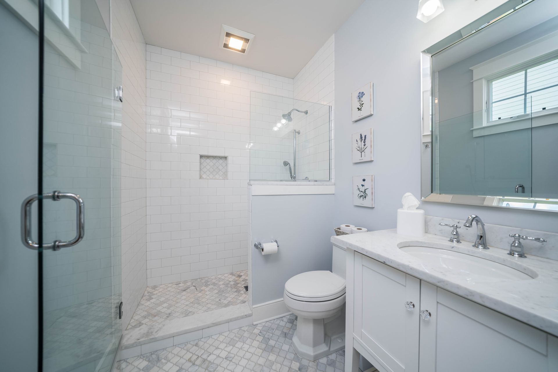 A bathroom with a toilet , sink , and walk in shower.
