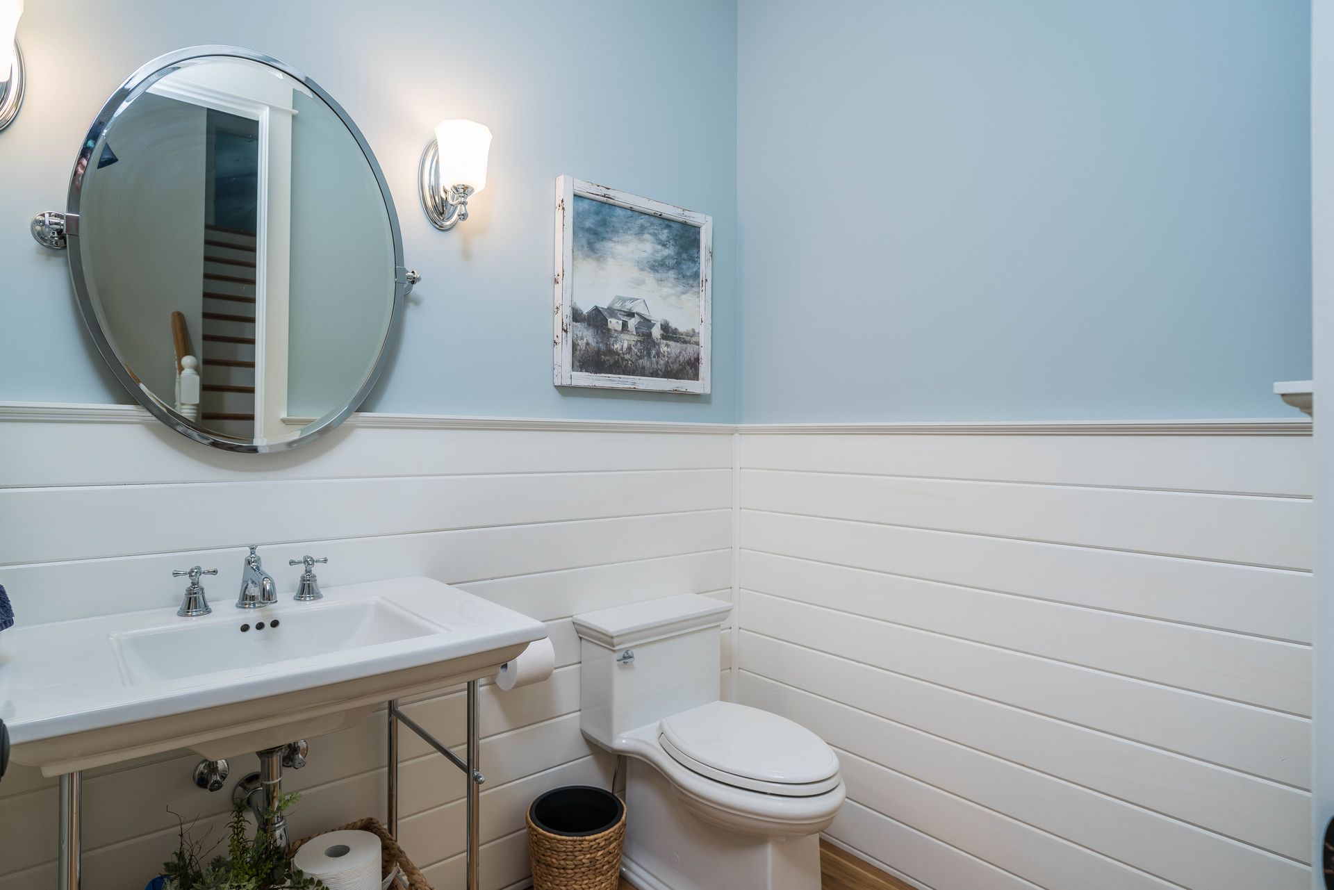 A bathroom with a toilet , sink and mirror.