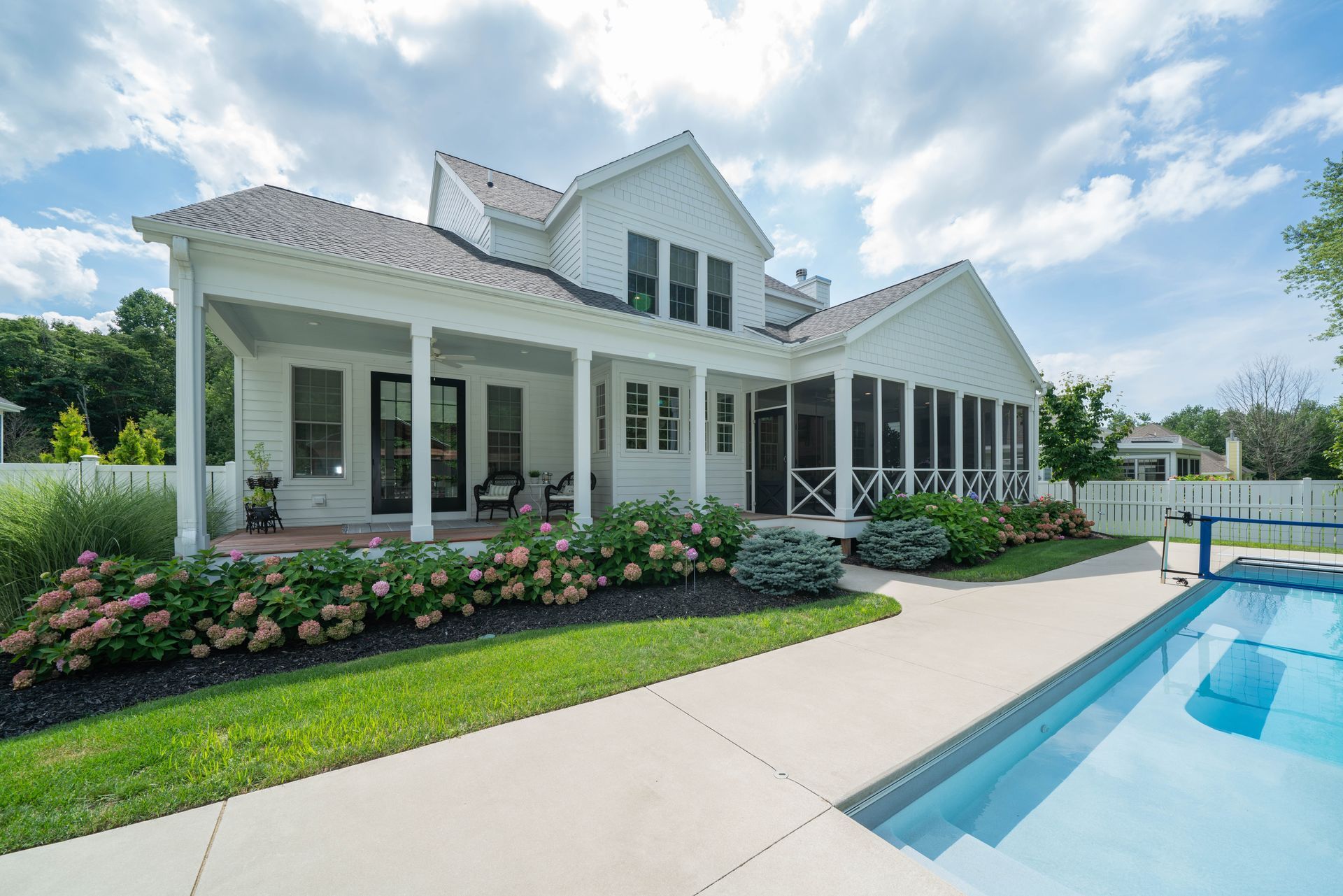 A large white house with a swimming pool in front of it.