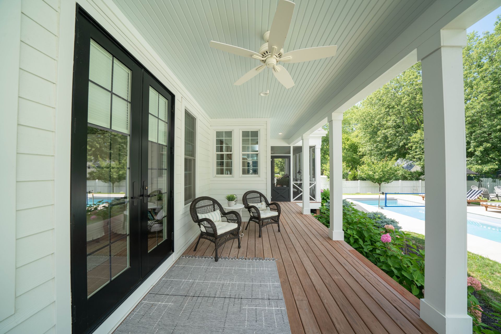 There is a ceiling fan on the porch of a house.