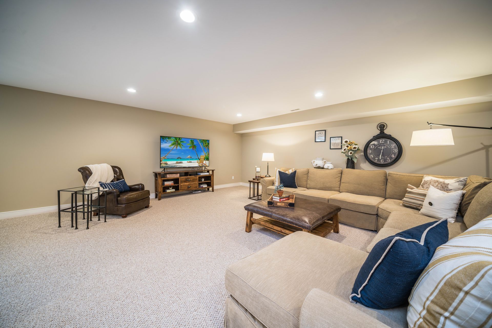 A living room with a couch , chairs , coffee table and television.