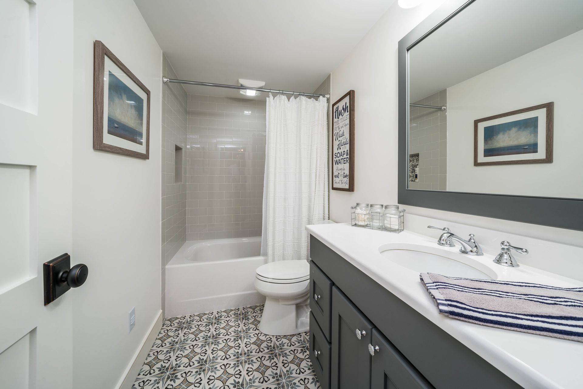 A bathroom with a toilet , sink , mirror and bathtub.