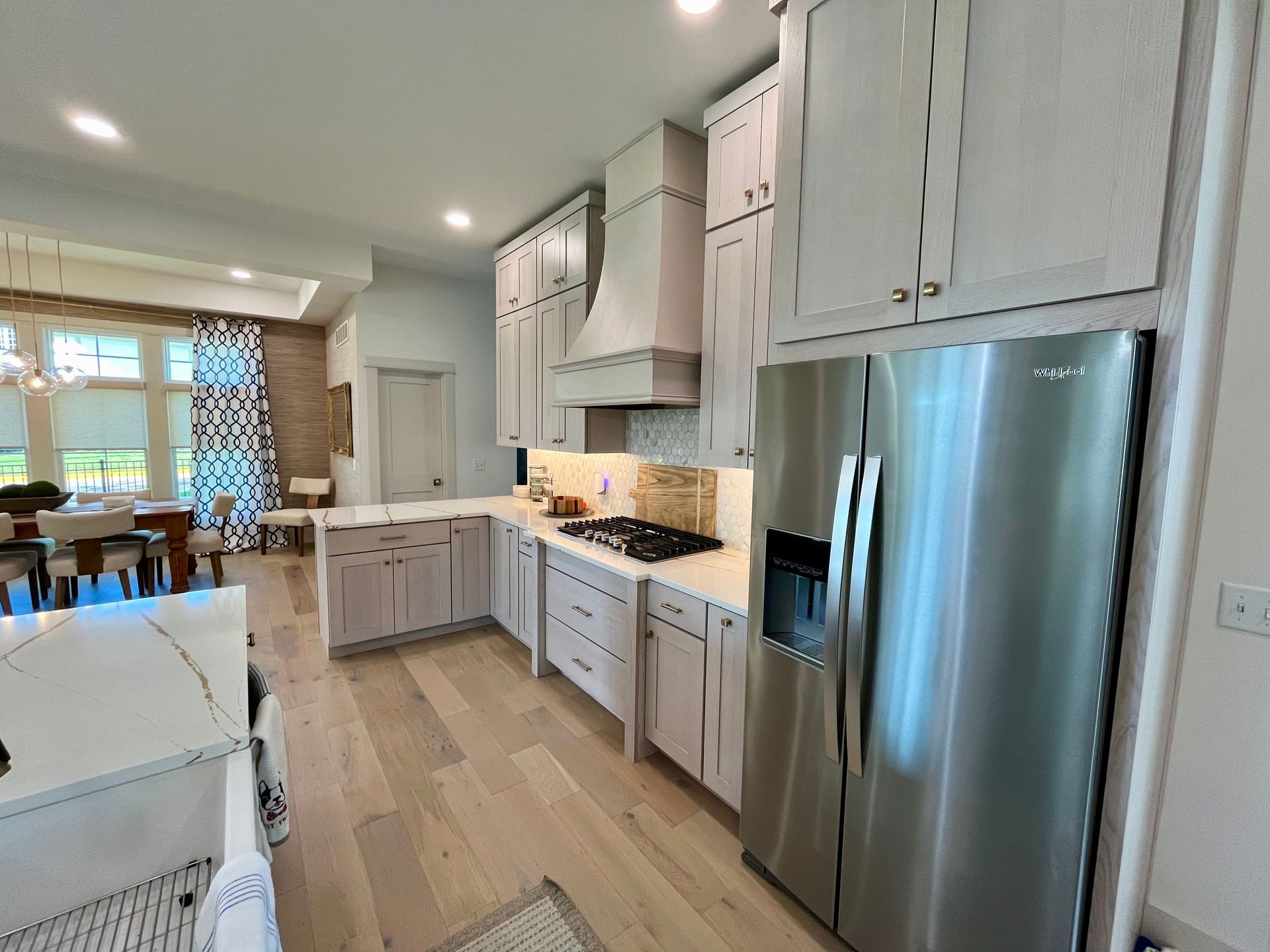 A kitchen with stainless steel appliances and white cabinets.