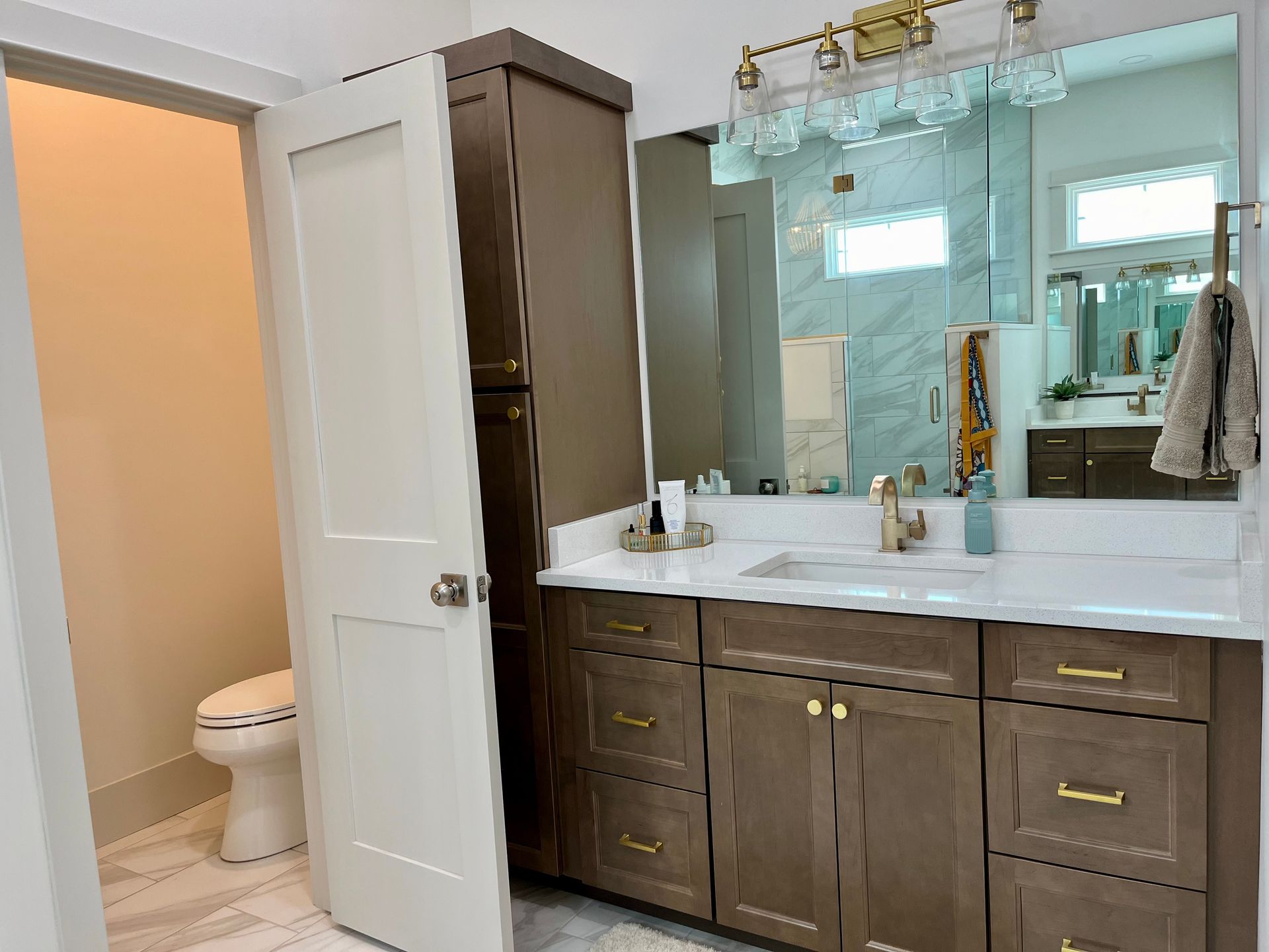 A bathroom with two sinks , a toilet , and a large mirror.