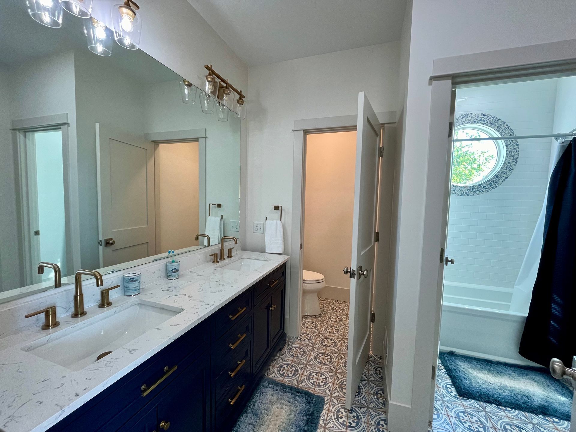 A bathroom with two sinks , a toilet , and a large mirror.