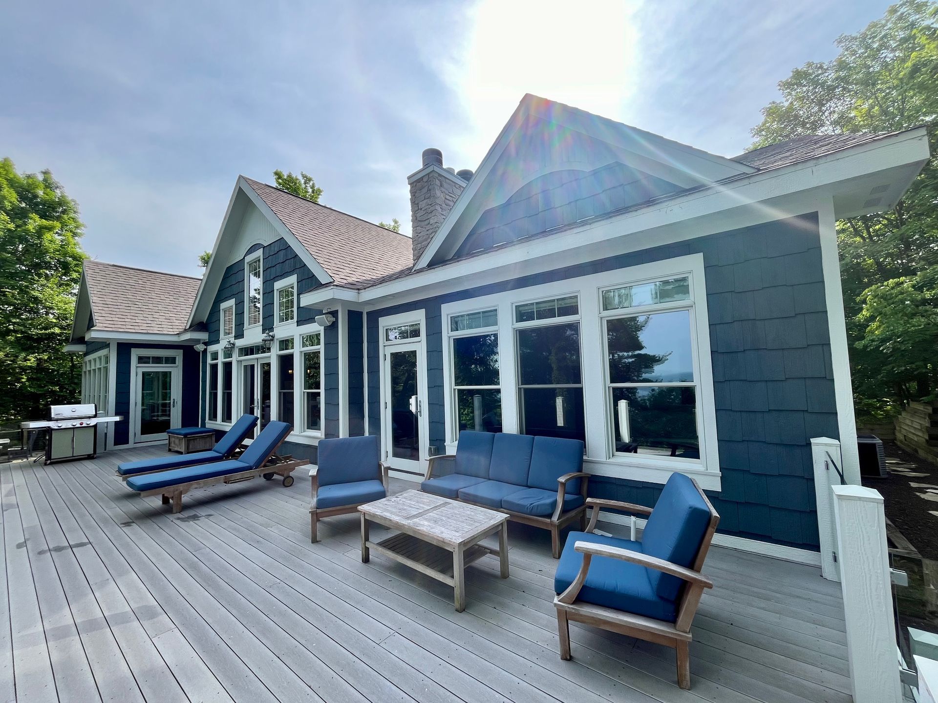 A large blue and white house with a large deck