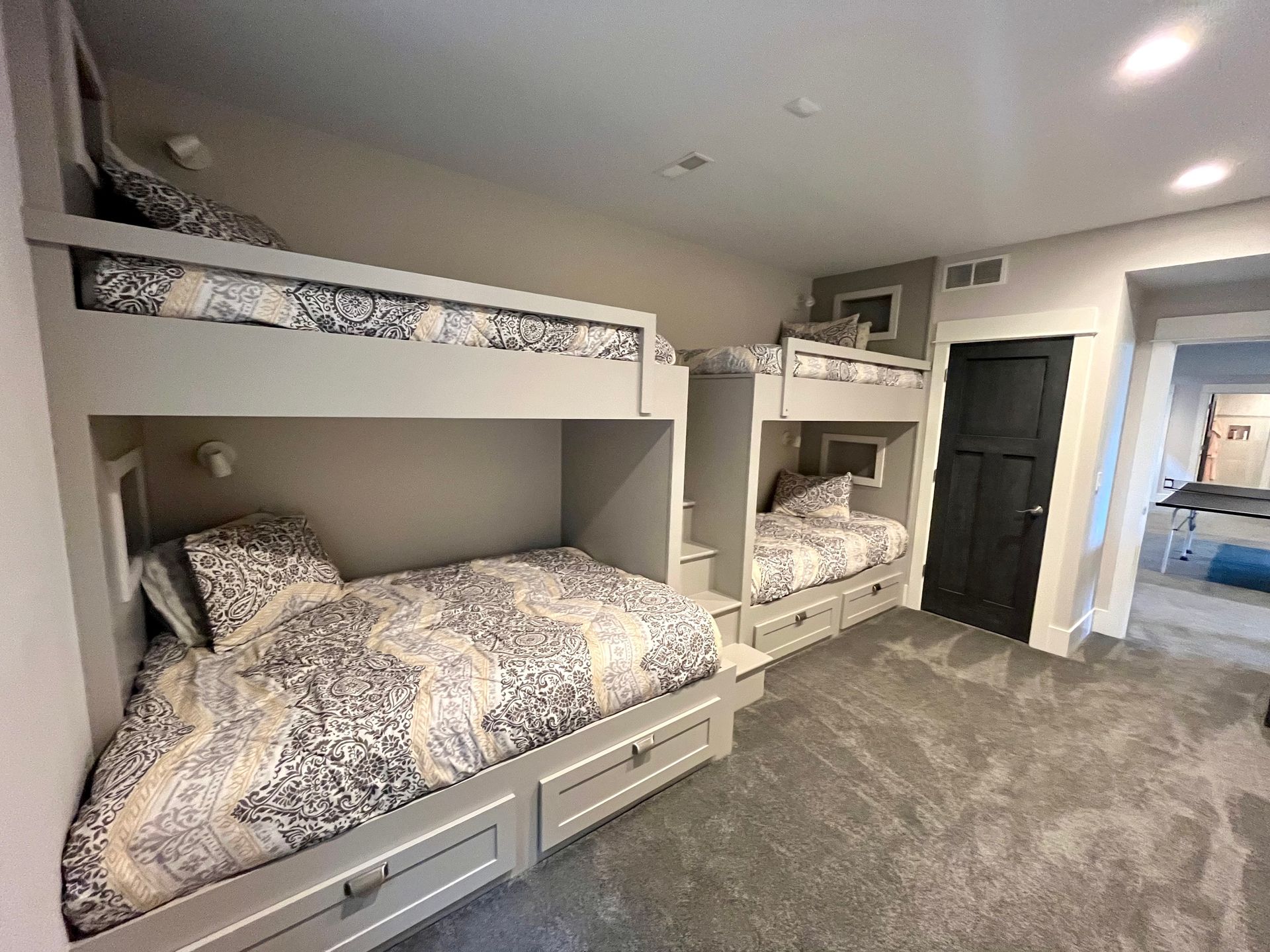 A bedroom with three bunk beds and a door.