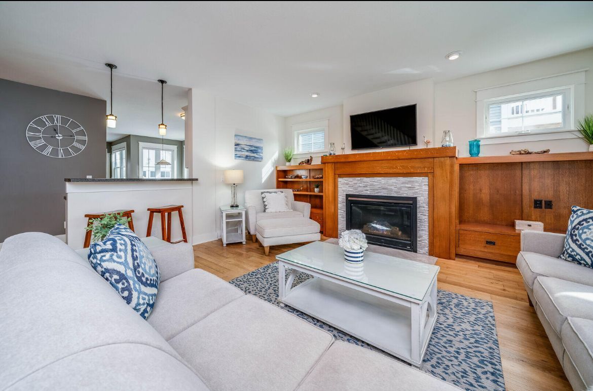 A living room with a couch , chair , coffee table and fireplace.