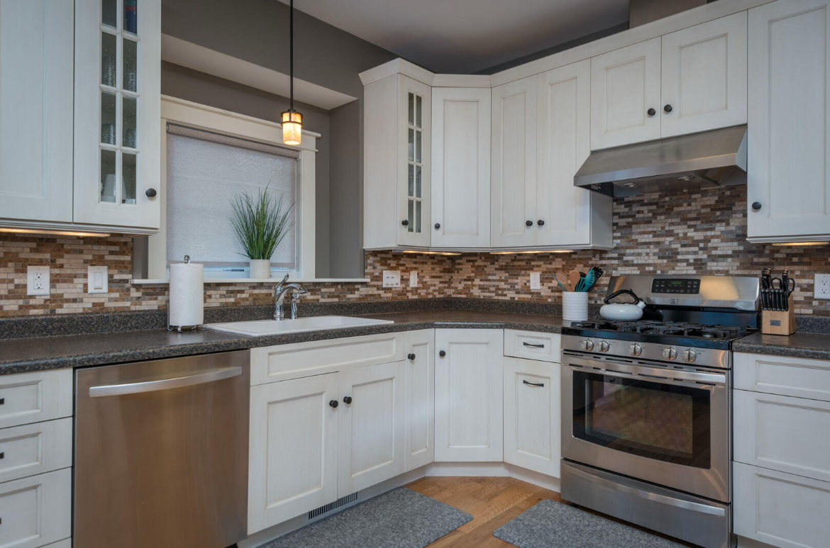 A kitchen with white cabinets and stainless steel appliances.