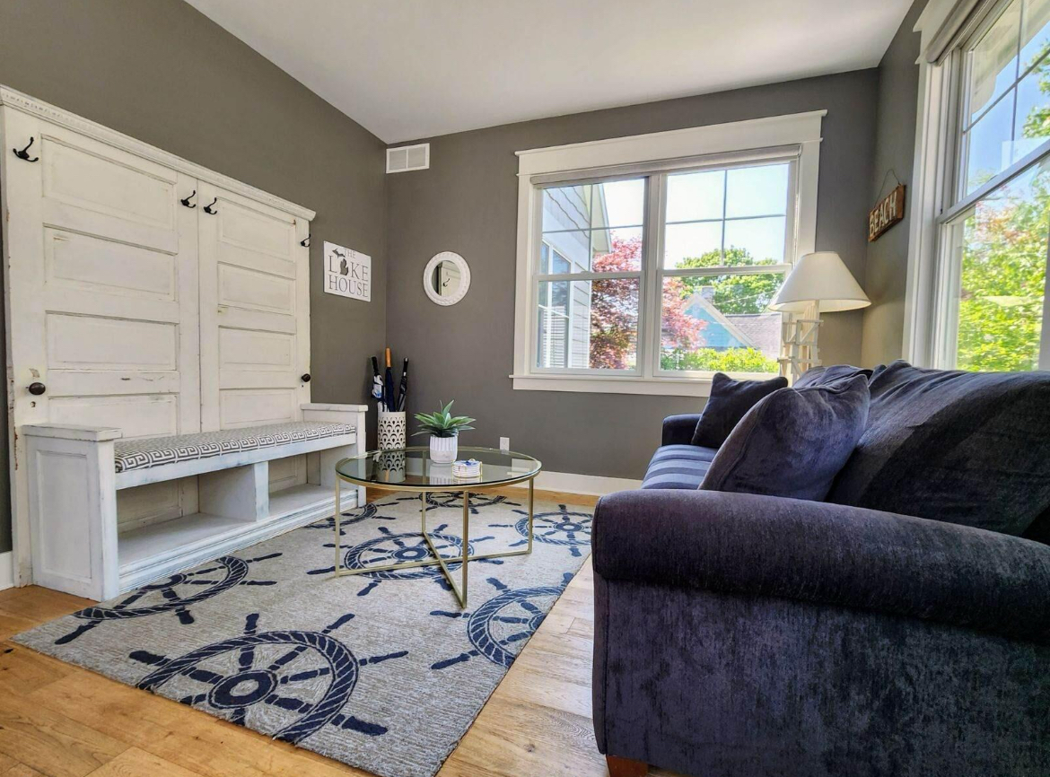 A living room with a couch , chair , table and window.