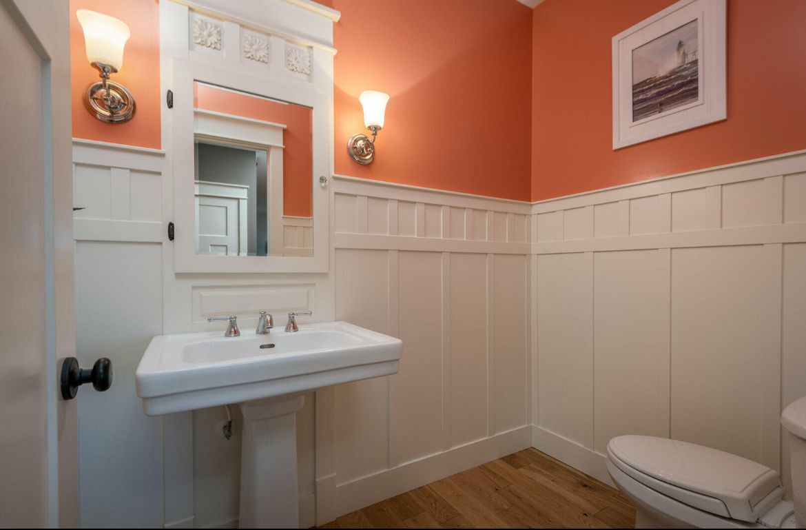 A bathroom with a sink a toilet and a mirror