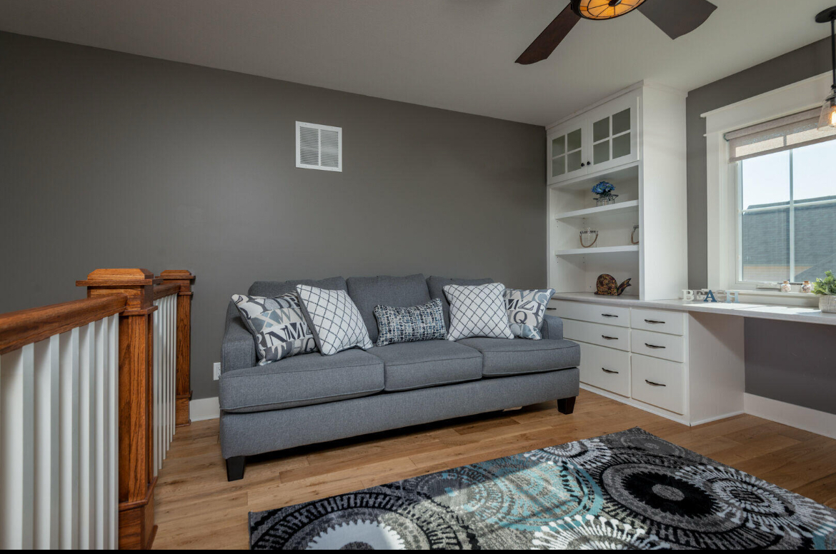 A living room with a couch and a ceiling fan