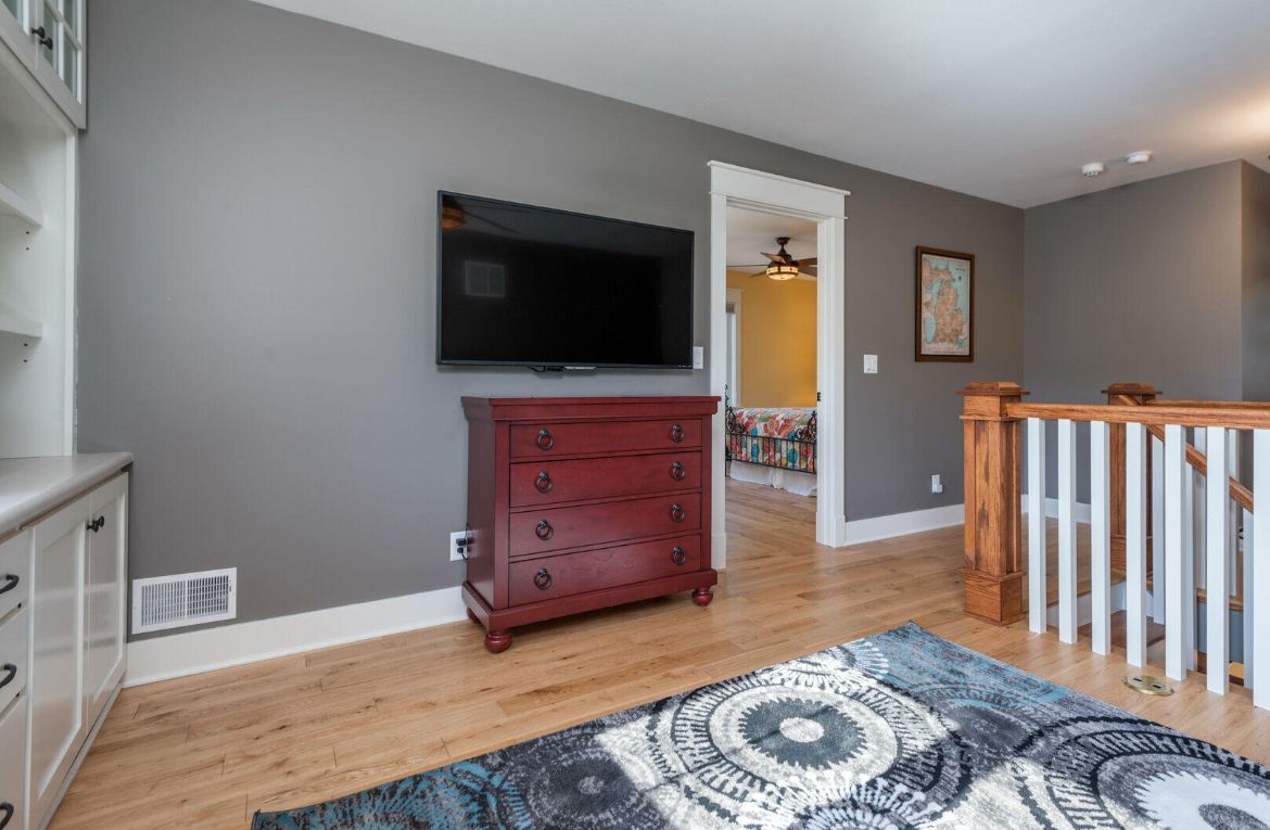 A living room with hardwood floors and a flat screen tv on the wall.