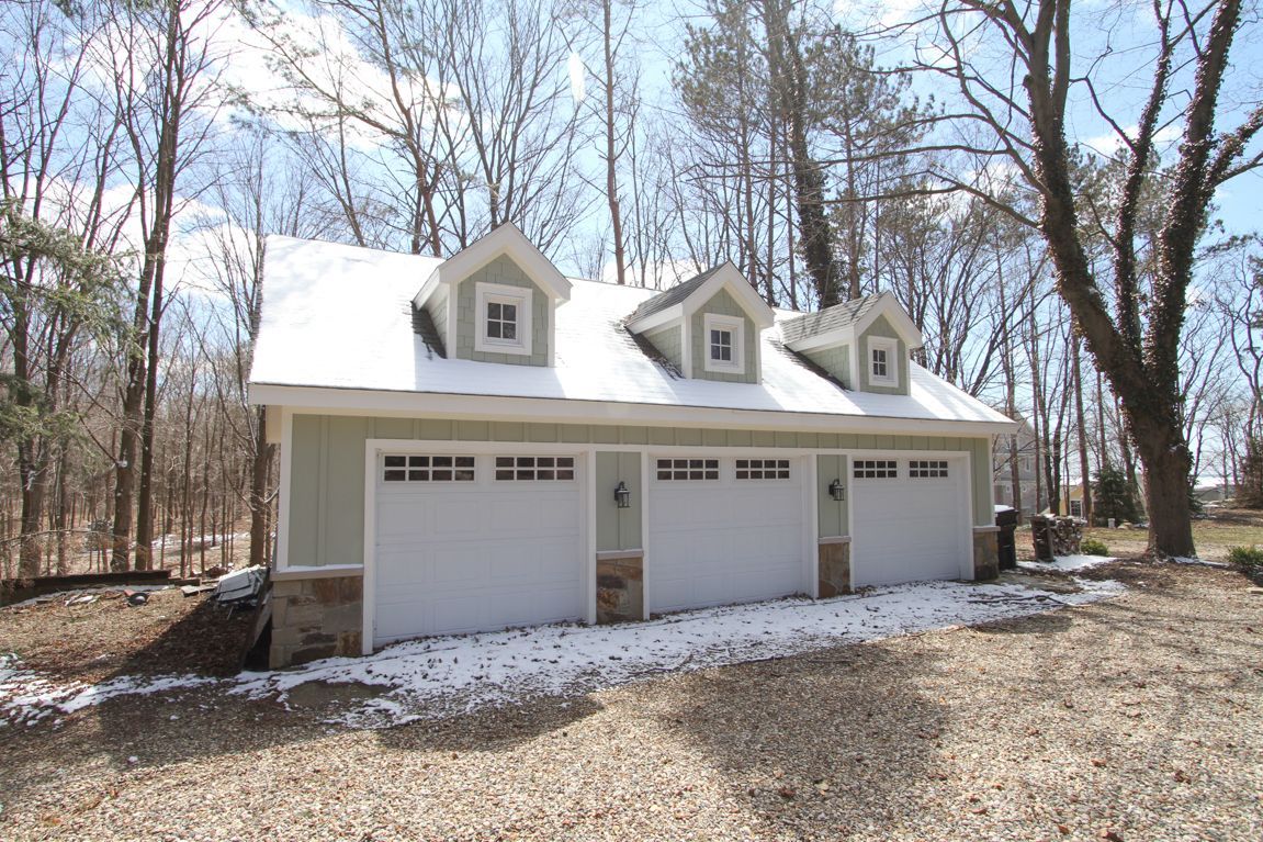 A garage with three doors and a snowy roof