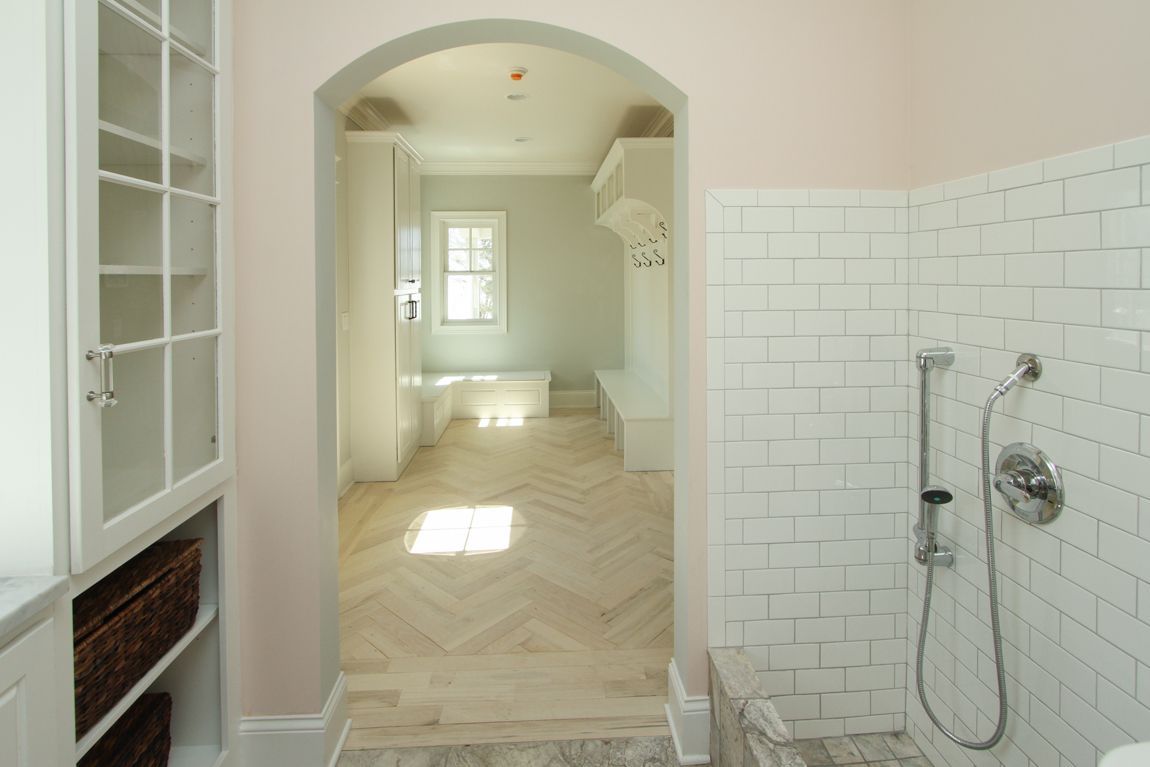 A bathroom with white tiles and a walk in shower