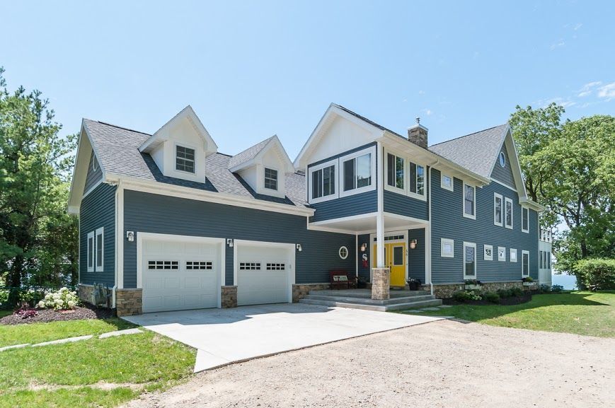The front of a large house with two garages and a driveway.