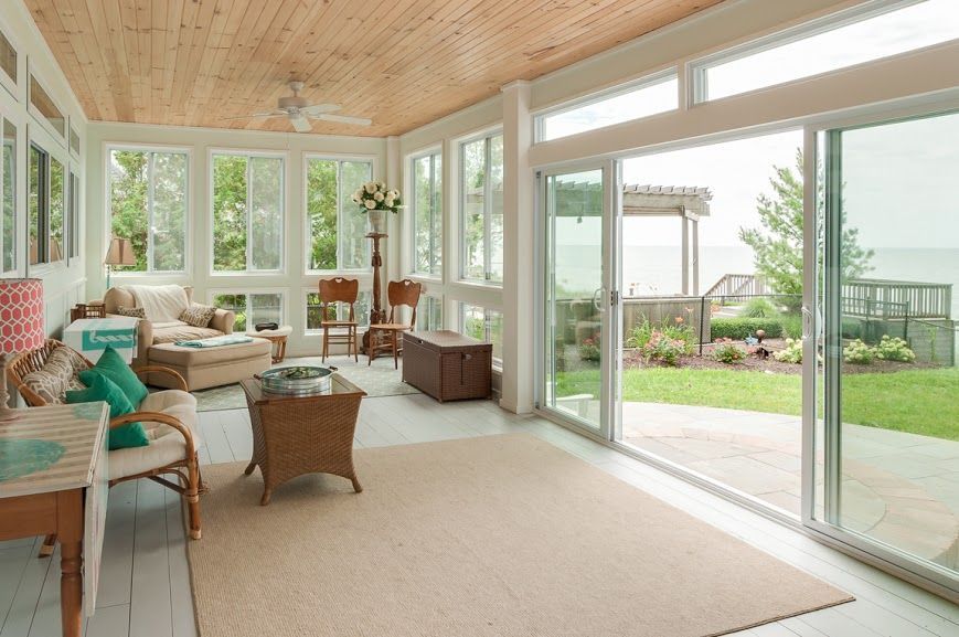 A living room with a lot of windows and a view of the ocean.