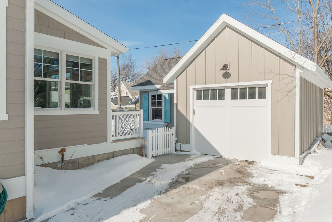A house with a garage and a driveway covered in snow.