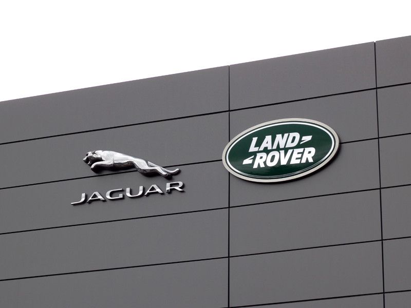 Jaguar and Land Rover logos on a gray building facade