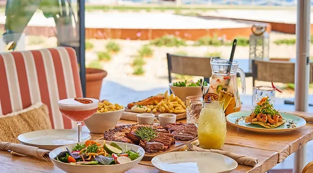 A table topped with plates of food and drinks.